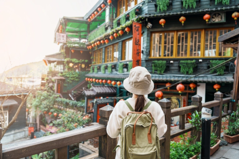 woman traveler visiting taiwan tourist with hat backpack sightseeing jiufen old street village with tea house background landmark popular attractions near taipei city travel concept